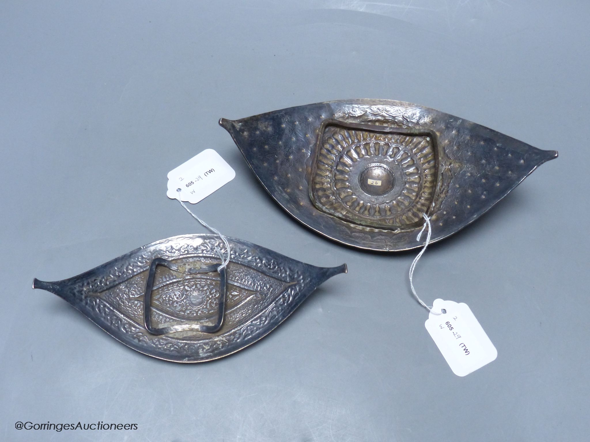 A Chinese Straits large white metal belt buckle, of curved navette form and a similar smaller buckle, L 24.5cm & 20.5cm